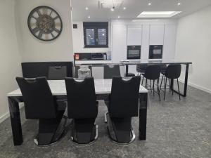 a dining room with a table and chairs and a clock at Chez Alex in Verviers