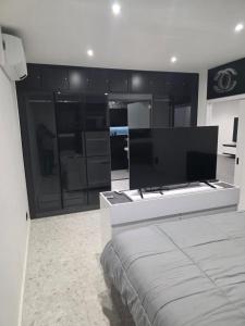 a bedroom with a bed and a large television at Chez Alex in Verviers