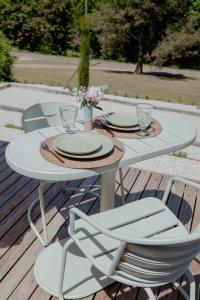 a white table with two chairs and plates on it at Tiny House - Nature&calme - Pétanque&barbecue in Quincey
