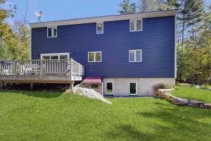 a large blue house with a porch and a deck at Frozen Jamaica in Jamaica