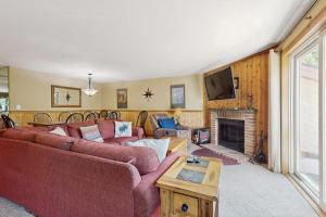 a living room with a red couch and a fireplace at Snow Mountain Village 36D in Dover
