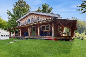 a small house with a porch on a lawn at Wandering Trails Retreat in Cambridge