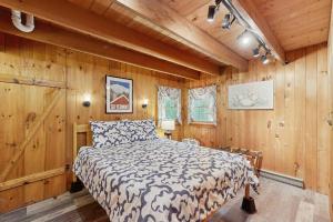 a bedroom with a bed in a room with wooden walls at Wandering Trails Retreat in Cambridge