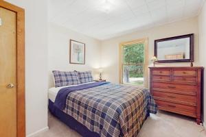 a bedroom with a bed and a dresser and a mirror at North Hill Cross Retreat in Ludlow