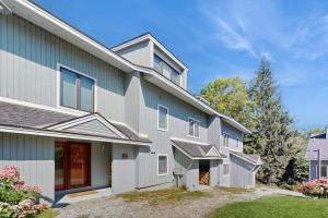 a gray house with a yard at Slopeside A2 in Stratton