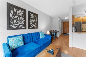 a living room with a blue couch and a kitchen at Blazing Saddles #102 in Breckenridge