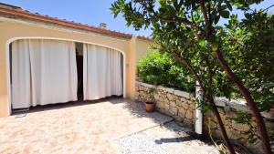a patio with a white curtain next to a building at Villa Angedras in San Teodoro