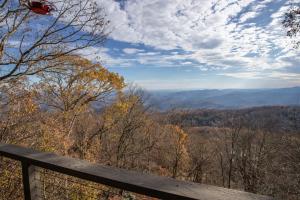 a view of the mountains from a wooden railing at Out On A Limb in Blowing Rock