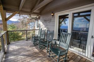 a porch with four chairs sitting on it at Out On A Limb in Blowing Rock