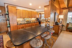 a kitchen with wooden cabinets and a black counter top at Out On A Limb in Blowing Rock +32 photos