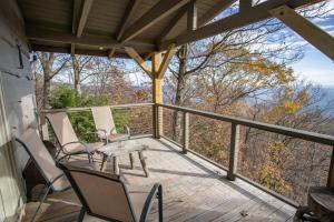 a wooden deck with chairs and a table on it at Out On A Limb in Blowing Rock