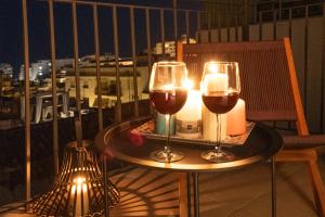 two glasses of wine and candles on a table on a balcony at Luz House Marbella Hostal in Marbella