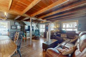 a living room with a leather couch and a table at Lakefront Living in Bomoseen