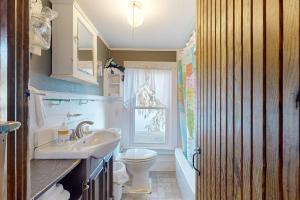 a bathroom with a sink and a toilet and a window at Lakefront Living in Bomoseen +47 photos