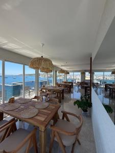a restaurant with tables and chairs and a view of the ocean at Nese Pension in Bodrum City