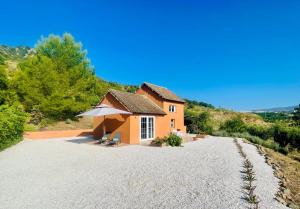 a small house with an umbrella on a gravel road at Casita Tierra De Suerte in Pizarra