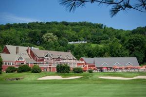 a large red building with a golf course in front at Mill Run 10E in Quechee