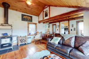 a living room with a leather couch and a fireplace at Grizzly Pines in Jay
