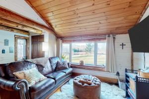 a living room with a leather couch and a window at Grizzly Pines in Jay +40 photos