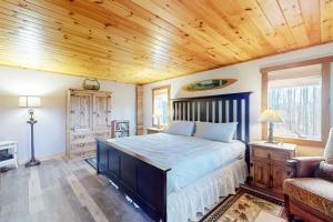 a bedroom with a large bed with a wooden ceiling at Grizzly Pines in Jay