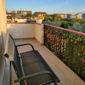 a chair sitting on a balcony with a view at ANAMI' Suite Apartament in Bovalino Marina
