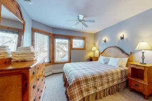 a bedroom with a bed and a dresser and windows at Jay Peak Village Home 375 in Jay +49 photos