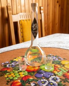 a bottle sitting on a table with two glasses at Villa Vishensburg in Višni