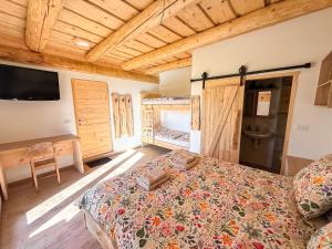 a bedroom with a bed and a desk and a television at Village Vista in Rob