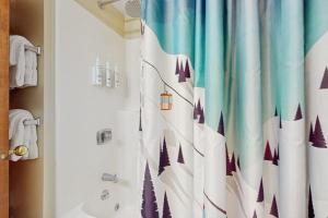 a bathroom with a shower curtain with a snow scene at The Seasons G17 in West Dover +42 photos