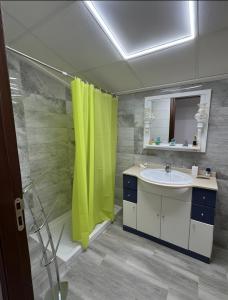 a bathroom with a sink and a green shower curtain at Casa Bartolo in Vélez-Rubio +20 photos