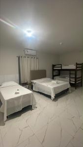 a room with two beds and a table in it at Pousada Brilho dos Lençóis in Barreirinhas +47 photos