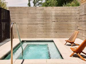 a small swimming pool with two chairs and a fence at AutoCamp Asheville in Asheville