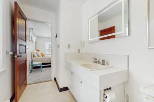 a white bathroom with a sink and a mirror at Fawn Ledge in Jamaica +42 photos