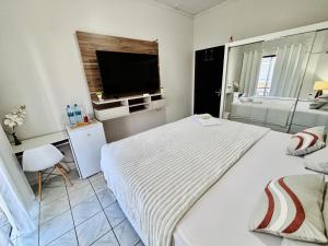 a bedroom with a large bed and a television at Hospedagem Domiciliar em Lucas do Rio Verde in Lucas do Rio Verde
