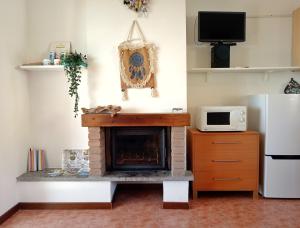 a living room with a fireplace and a microwave at Casa Oscar in Catabbio +23 photos