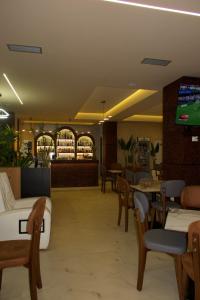 a restaurant with tables and chairs and a tv at Hotel Frida in Himare