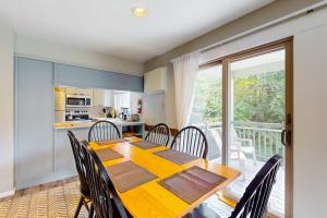 a kitchen and dining room with a table and chairs at Smugglers' Notch Resort Slopeside 39 in Jeffersonville