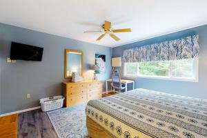 a bedroom with a bed and a ceiling fan at Smugglers' Notch Resort Slopeside 39 in Jeffersonville