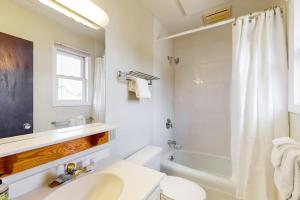 a bathroom with a toilet and a sink and a shower at Smugglers' Notch Resort Slopeside 39 in Jeffersonville +30 photos