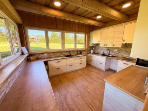 a large kitchen with wooden floors and windows at Village Vista in Rob