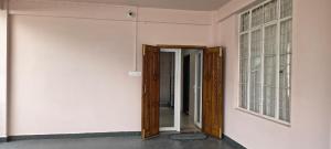 an empty room with two doors and a window at Townhouse Mylliem Formerly Infinity Bed & Breakfast in Shillong