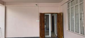 a hallway with doors and windows in a room at Townhouse Mylliem Formerly Infinity Bed & Breakfast in Shillong