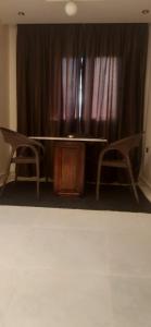 a table and two chairs in front of a curtain at جسر السويس نفرتاري in Obour