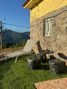 a patio with a bench and a table and a building at Adoria GuestHouse in Adoria