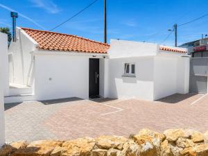 a white house with a door in a parking lot at Modern Studio with Private Patio near Cascais & Sintra in Alcabideche