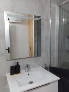 a bathroom with a white sink and a mirror at DUPLEX 3eme étage in Le Vigan