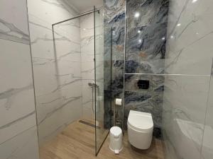 a bathroom with a toilet and a glass shower at The Onyx Residence in Loutraki +9 photos