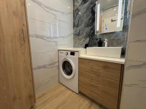 a bathroom with a washing machine and a sink at The Onyx Residence in Loutraki