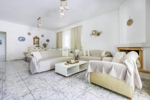 a living room with two couches and a fireplace at Casa Mia Skopelos - Spacious 3-Bedroom House near Stafylos Beach in Skopelos Town +24 photos