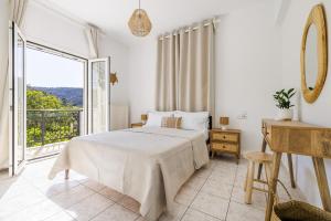 a bedroom with a bed and a large window at Casa Mia Skopelos - Spacious 3-Bedroom House near Stafylos Beach in Skopelos Town